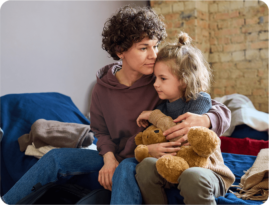Mother and child cuddling with teddy bear.